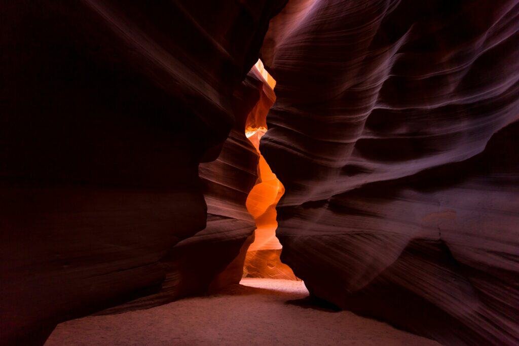 Sunlight filtering through the narrow, winding passage of Antelope Canyon, illuminating the smooth sandstone walls.